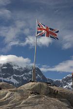 The Union Jack surrounded by a group of loyal subjects of the crown.